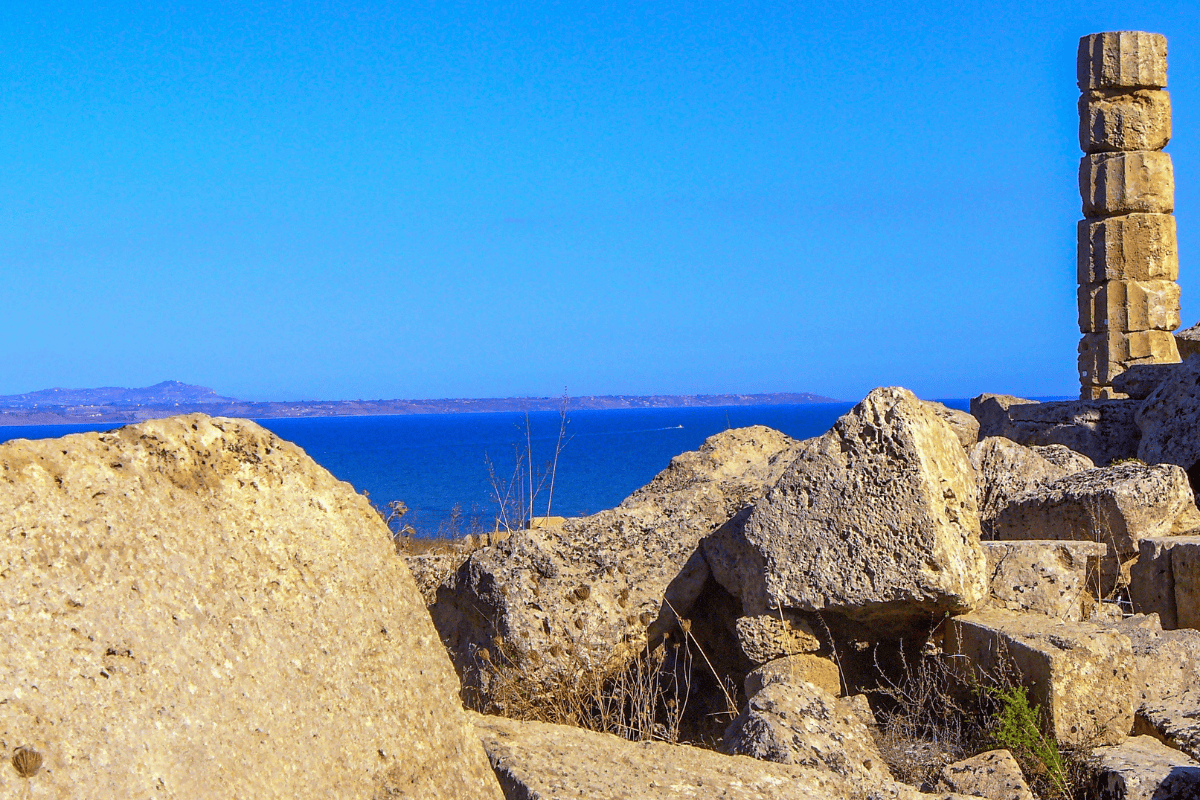 Una colonna solitaria si erge tra i ruderi di Selinunte, con il sereno Mare Mediterraneo sullo sfondo